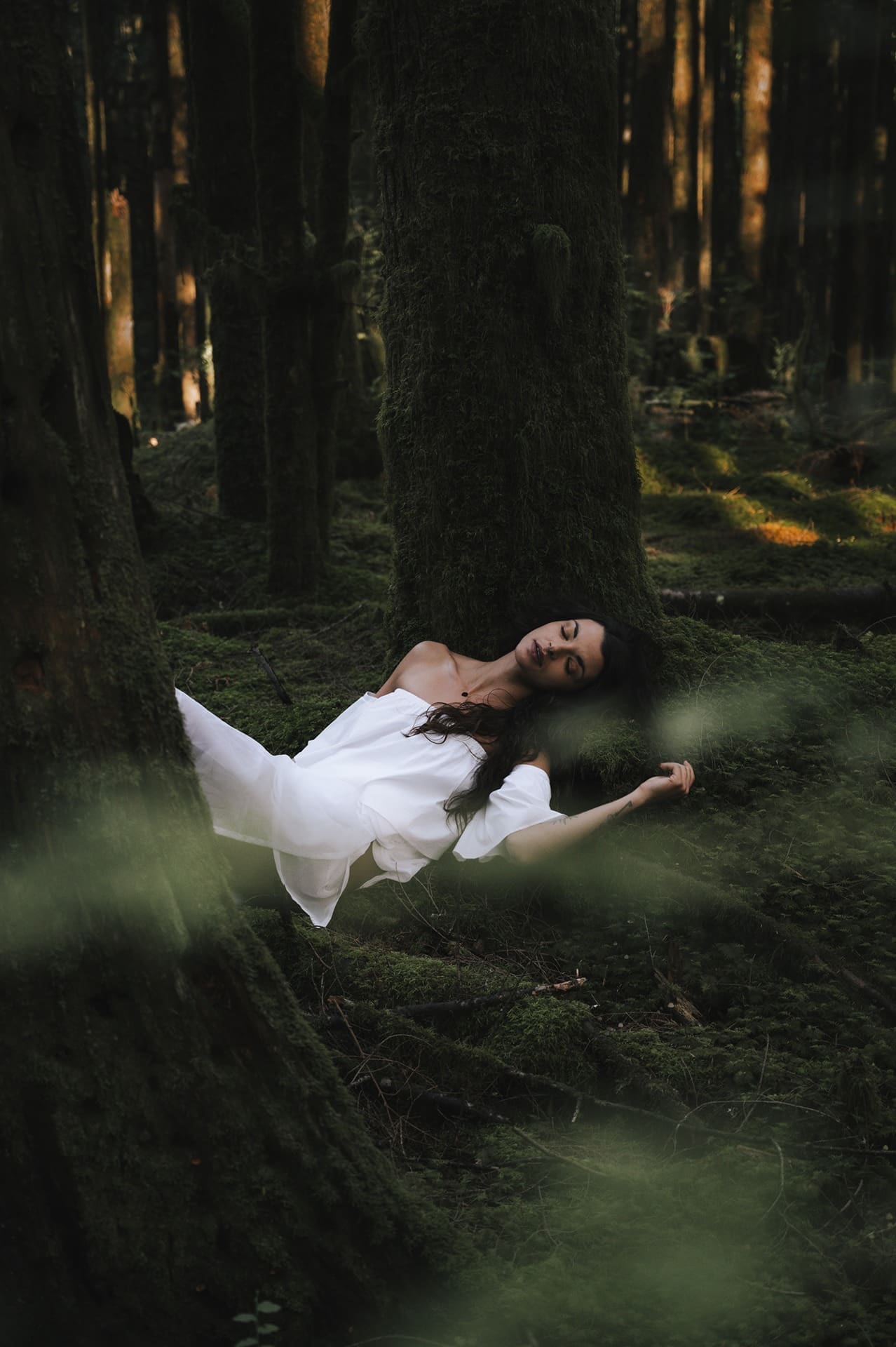 Women laying in mossy forest